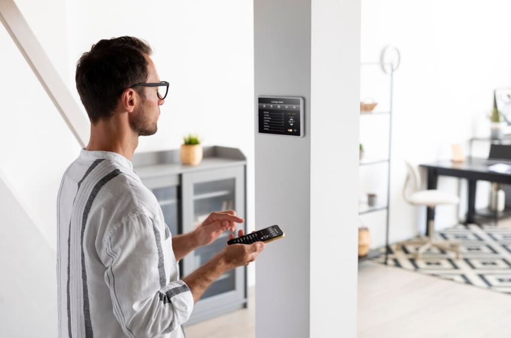 Man using a remote for the smart control panel in the home