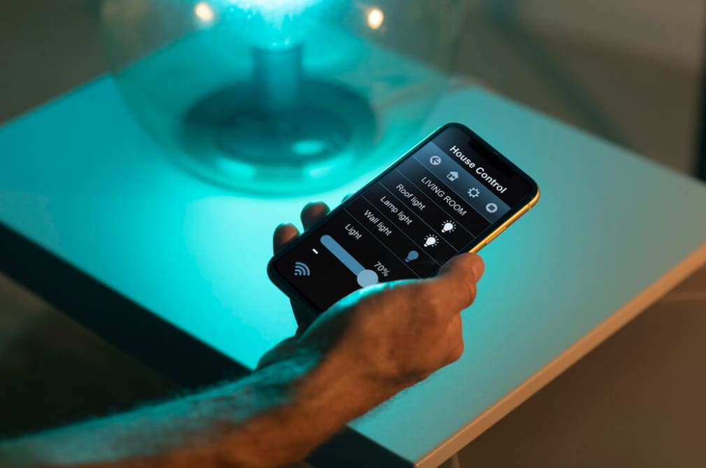 Close-up of a hand holding a smartphone controlling smart lighting